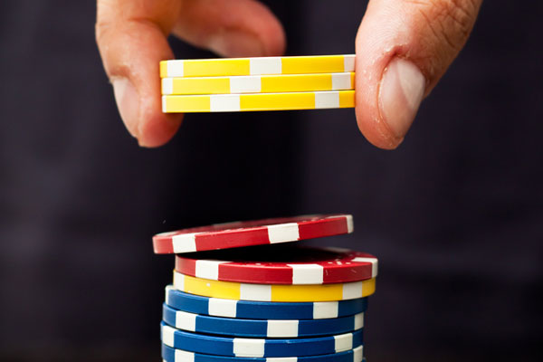 a hand dropping poker chips into a stack
